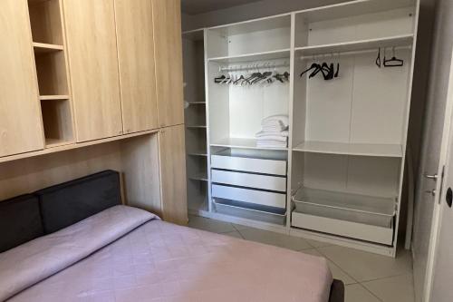 a bedroom with a bed and an empty closet at Plumosus in Arma di Taggia