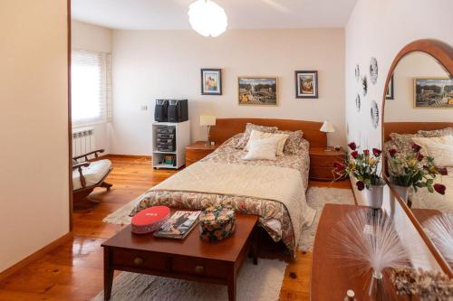 a bedroom with a large bed and a table at Casa Juliana in Ribadavia