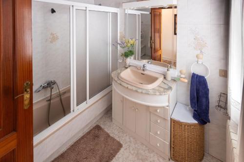 a bathroom with a sink and a shower and a mirror at Casa Juliana in Ribadavia