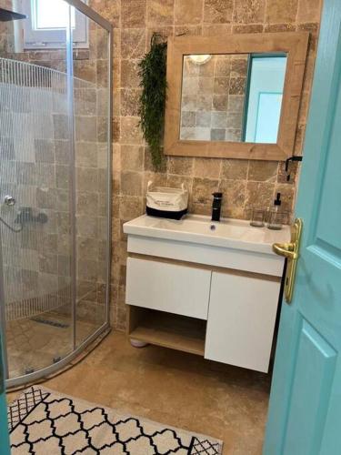 a bathroom with a sink and a shower with a mirror at Doğa içinde havuzlu villa in Aydın