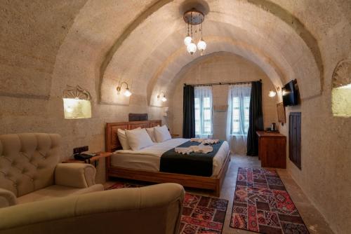 a bedroom with a bed and a couch in a room at Göreme Escape Cave Suites in Goreme