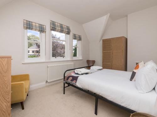 ein Schlafzimmer mit einem Bett und zwei Fenstern in der Unterkunft Pass the Keys Stylish apartment in stunning location plus parking in Bath