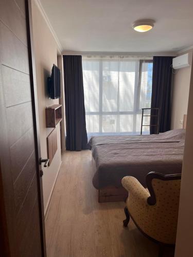 1 dormitorio con 1 cama, 1 silla y 1 ventana en Villa Premium Shekvetili, en Shekhvetili