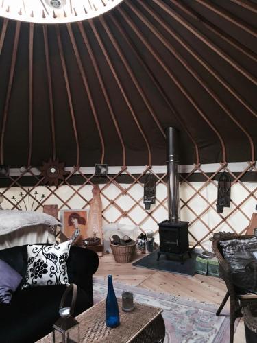 a living room with a yurt with a wood stove at Elodie Yurt in Bishopsteignton