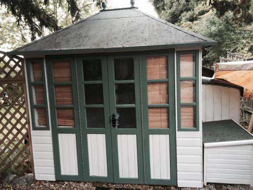 zielona i biała szopa z szarym dachem w obiekcie Elodie Yurt w mieście Bishopsteignton