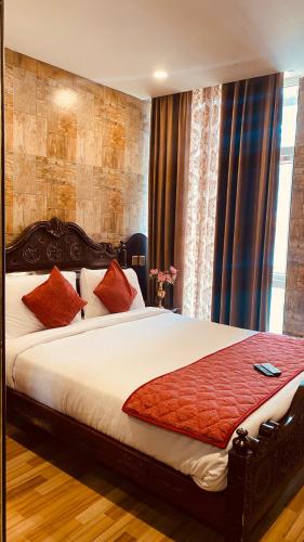 a bedroom with a large bed with red pillows at HYDERS PARK- THE LUXURY HOTEL in Kodaikānāl