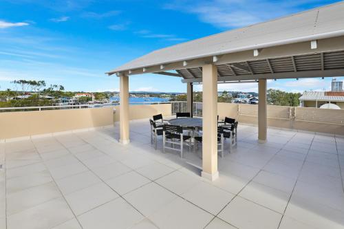 a patio with a table and chairs on a roof at Spinnaker Quays in Mooloolaba