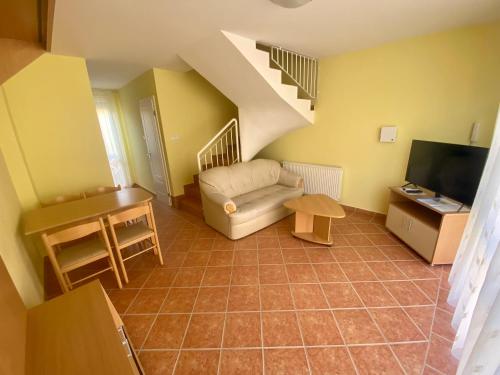 a living room with a couch and a staircase at Hajnal Vendégház in Hajdúszoboszló