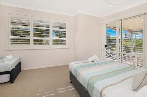 a bedroom with two beds and a window at Spinnaker Quays in Mooloolaba