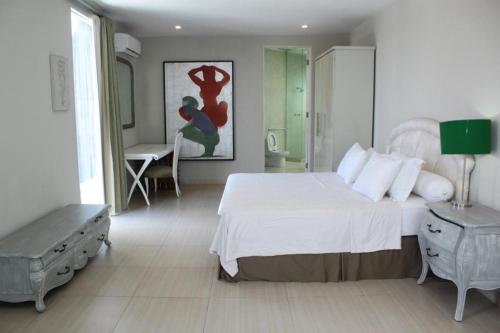 a bedroom with a large white bed and a table at Jade Waters 05 in Candi