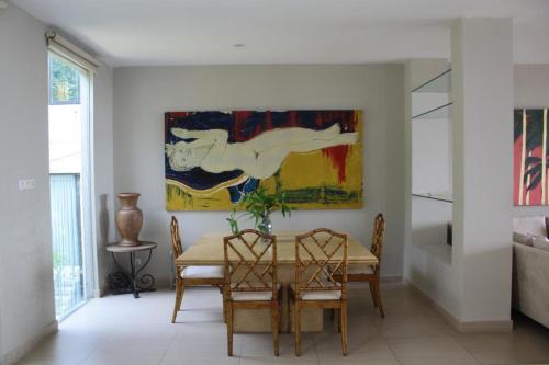 a dining room with a table and a painting on the wall at Jade Waters 05 in Candi