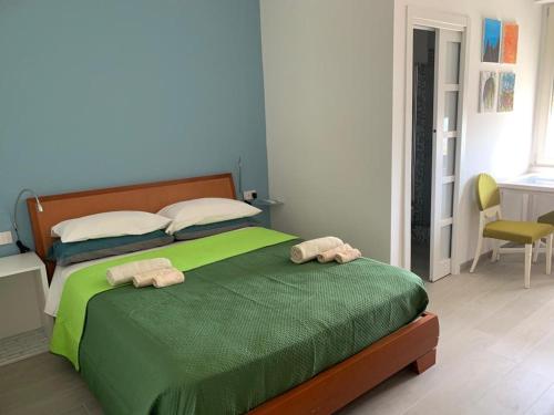 - une chambre avec un lit vert et 2 serviettes dans l'établissement ViVa House Salerno, à Salerne