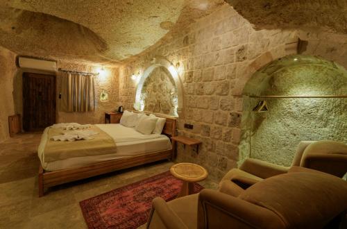 a bedroom with a bed and a couch in a room at Göreme Escape Cave in Göreme