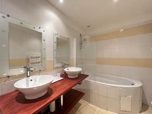 ein Badezimmer mit 2 Waschbecken und einer Badewanne in der Unterkunft Le Pierrotin - superbe 2ch au coeur de Toulouse in Toulouse