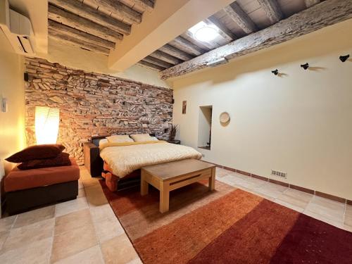ein Schlafzimmer mit einem Bett und einer Steinmauer in der Unterkunft Le Pierrotin - superbe 2ch au coeur de Toulouse in Toulouse