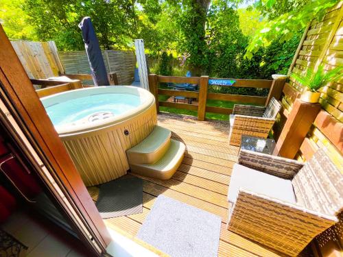 bañera de hidromasaje en una terraza con sillas en B&B Bourgeoisie***, en Frahan