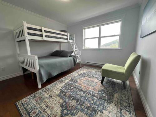 a bedroom with a bunk bed and a chair and a rug at Experience Coastal Charm-The Vista At Quidi Vidi! in St. John's