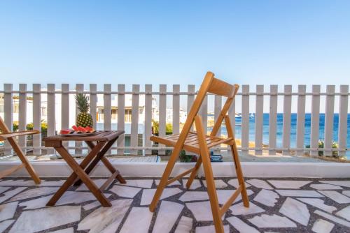 a chair and a table with a bowl of fruit on a balcony at Escape in Tinos in Tinos
