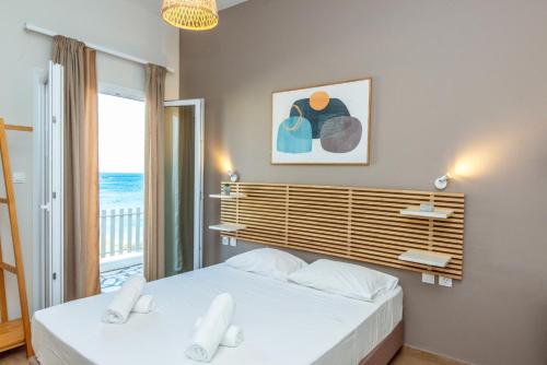 a bedroom with two beds and a view of the ocean at Escape in Tinos in Tinos
