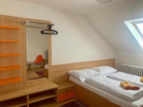 ein kleines Schlafzimmer mit einem Bett und einem Spiegel in der Unterkunft Penzion Ludor in Strážnice