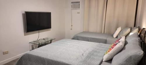 a hotel room with two beds and a flat screen tv at ADB TOWER ORTIGAS in Manila