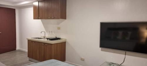 a kitchen with a flat screen tv on a wall at ADB TOWER ORTIGAS in Manila