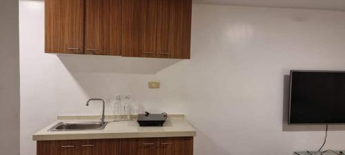 a kitchen with a sink and a flat screen tv at ADB TOWER ORTIGAS in Manila