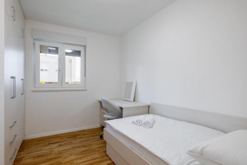 a bedroom with a bed and a desk and a window at Casa Linda in Podstrana