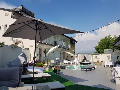 a patio with an umbrella and a swimming pool at borgo vecchio *DREAM* in Lonato del Garda