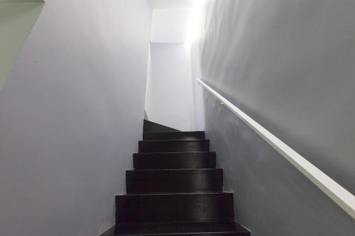 a stairway with black stairs and a white wall at Casa Valentina in Mantova