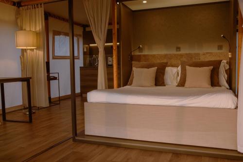 a bedroom with a large bed with a large mirror at Luna Minoica Suites and Apartments in Montallegro