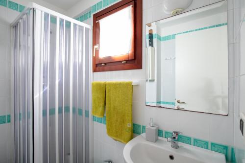 een badkamer met een wastafel en een spiegel bij Casa Olbiamare by Wonderful Italy in Olbia