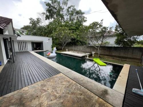 une arrière-cour avec une piscine et une terrasse en bois dans l'établissement Bungalow with Pool Karaoke PJ 12, à Petaling Jaya