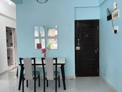 uma sala de jantar com paredes azuis e uma mesa e cadeiras em Angel Views 101, Chapel Road, Bandra West by Connekt Homes em Mumbai