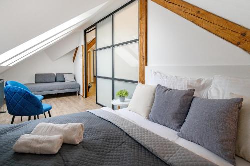 a bedroom with a large bed and a blue chair at Hotel Smrž in Sepekov