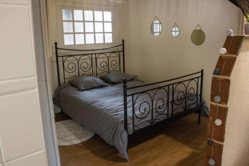 a bedroom with a black bed with a window at Columna Historya 2 in Bergerac