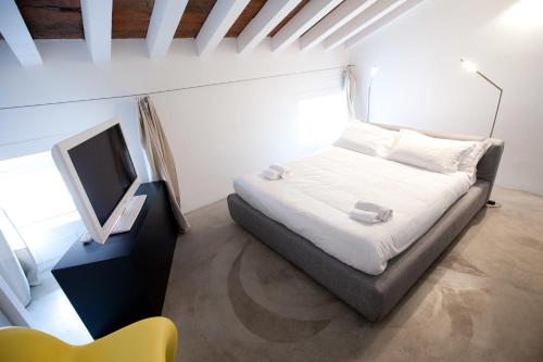 a small bedroom with a bed and a television at Casa Valentina in Mantova