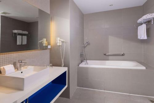 a bathroom with a white tub and a sink and a shower at Park Inn by Radisson Davao in Davao City