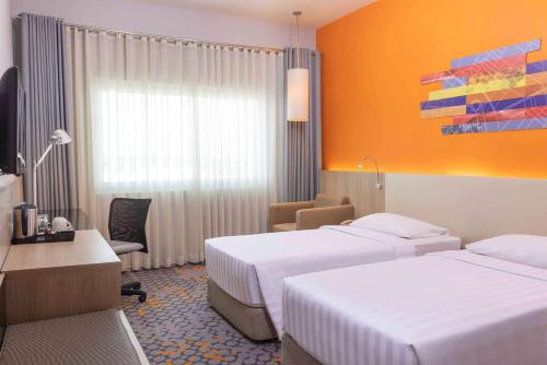 a hotel room with two beds and a desk at Park Inn by Radisson Davao in Davao City