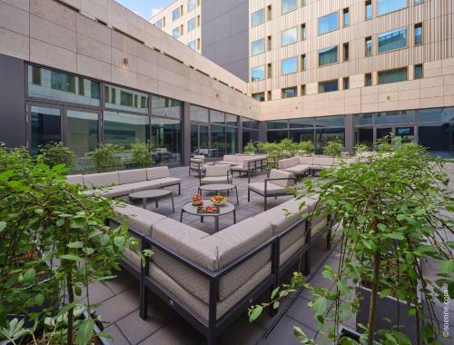 an outdoor patio with tables and chairs in front of a building at Dorint Hotel München/Garching in Garching bei München