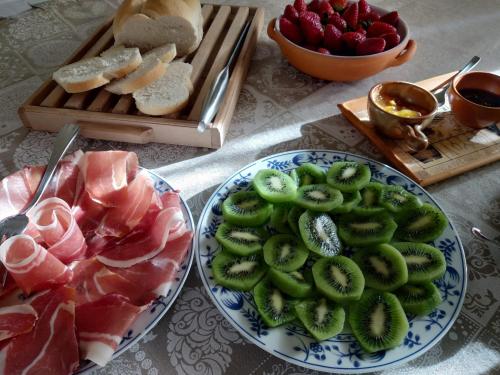 un tavolo con due piatti di cibo e un vassoio di frutta di B&B Palazzo Mestichelli Boutique Palace a Monteprandone