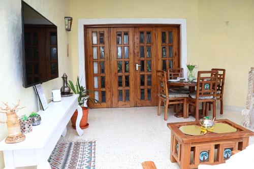a living room with a table and a wooden door at Tembo Baharini Beach Cottage in Malindi