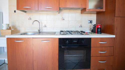 a kitchen with a sink and a stove at Sardinianworld - Casa Dei Bucanieri in Putzu Idu