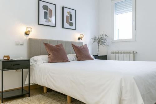 ein Schlafzimmer mit einem großen weißen Bett mit zwei Kissen in der Unterkunft Luxurious 2BR/2BA in Chueca in Madrid
