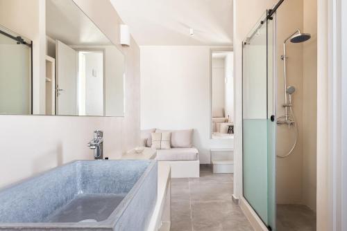 uma casa de banho com uma grande banheira azul em Kythea Suites Kythnos em Kythnos