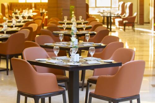 a row of tables and chairs with wine glasses on them at Cloud City Hotel in Al Baha