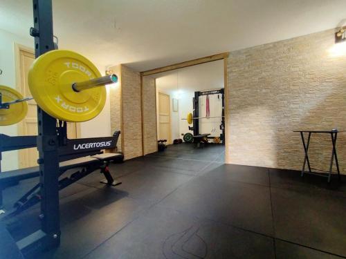 a gym with a large yellow barbell in a room at Le chalet du village in Chambave