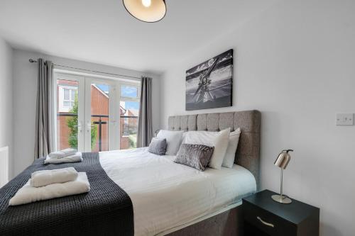 una camera da letto con un grande letto e una finestra di Ferndale Serviced 4 Bedroom 2 Bath house with Parking a Maidenhead