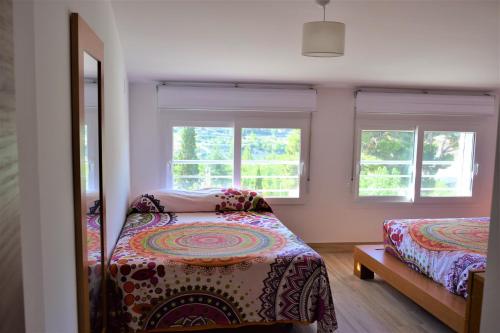 1 dormitorio con 2 camas y 2 ventanas en La LLar de Julia, en Tibi