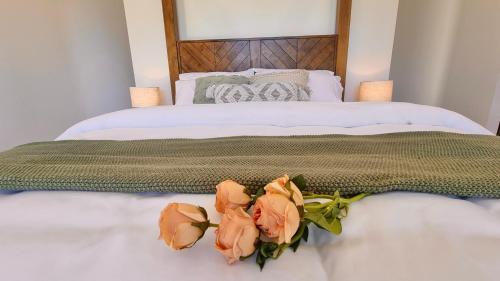 a bed with three flowers sitting on it at Ashiyana Escapes in Mount Tamborine